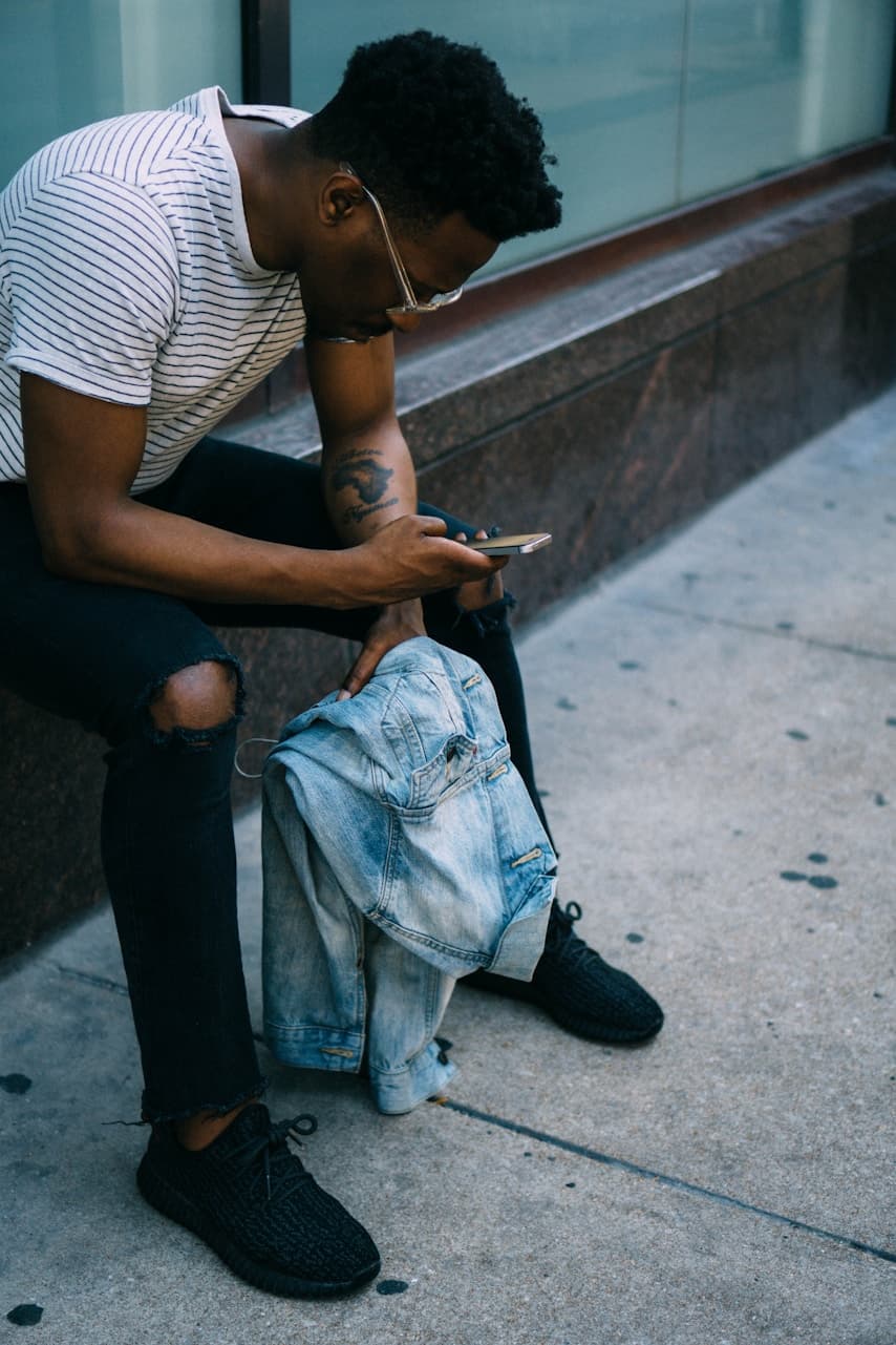 Person checking their phone while seated outside